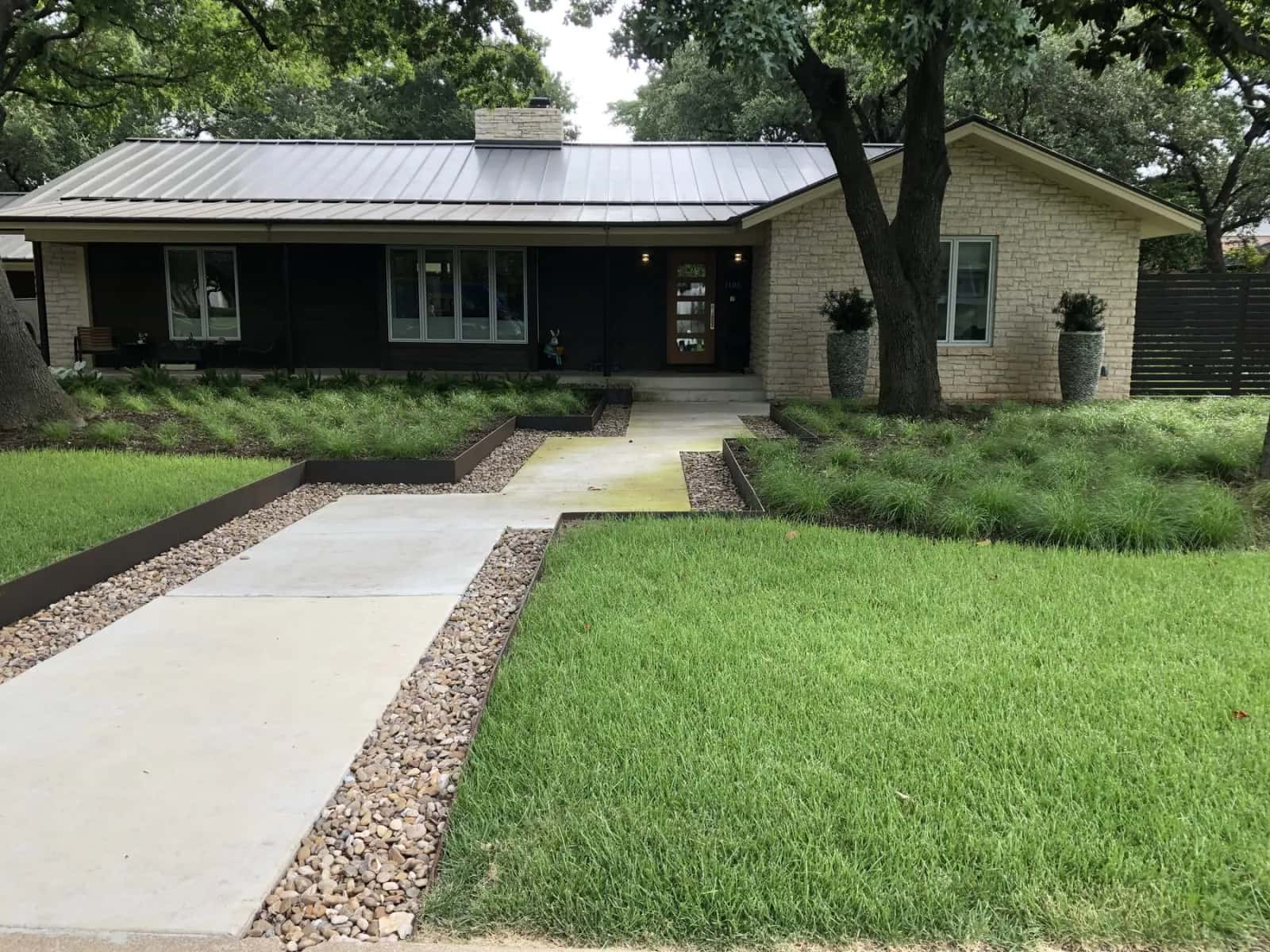 Austin reduced-lawn landscape with gravel, low planting, and a front walk
