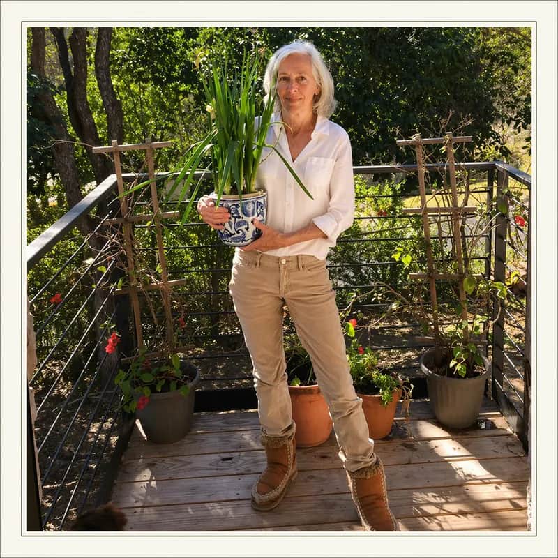 Cynthia Bond holding a potted plant in an Austin garden